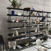 Modern black shelving unit displaying a variety of colorful notebooks and geometric paper patterns.