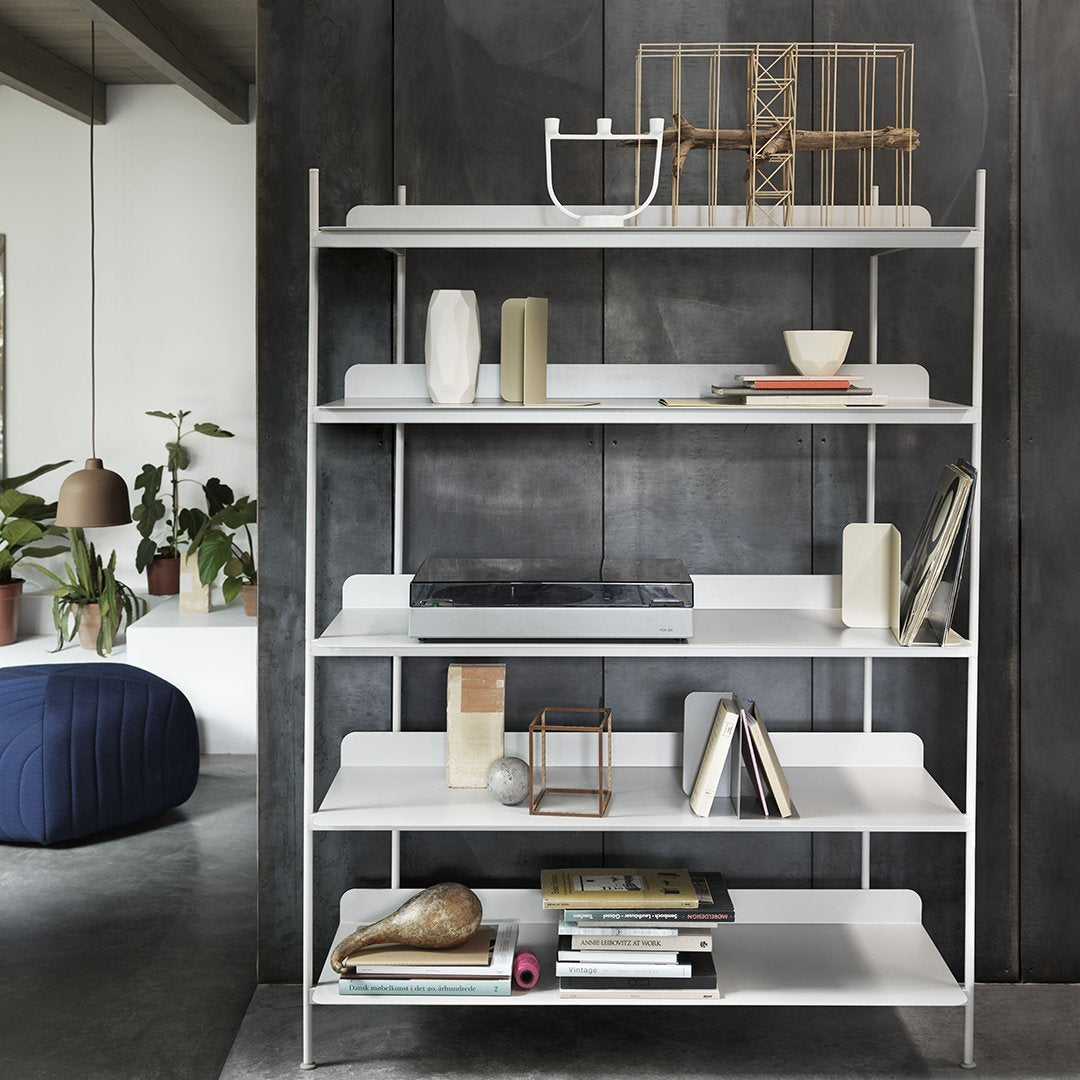 White modern shelving unit with sleek horizontal lines, set against a dark gray wall. Minimalist decor accents.