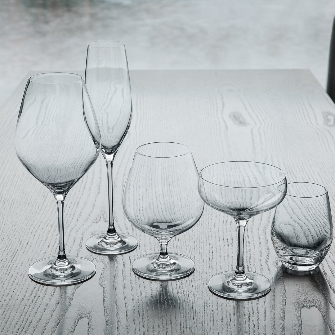 Set of five elegant clear glassware with varying shapes and sizes, showcasing sleek, modern designs.
