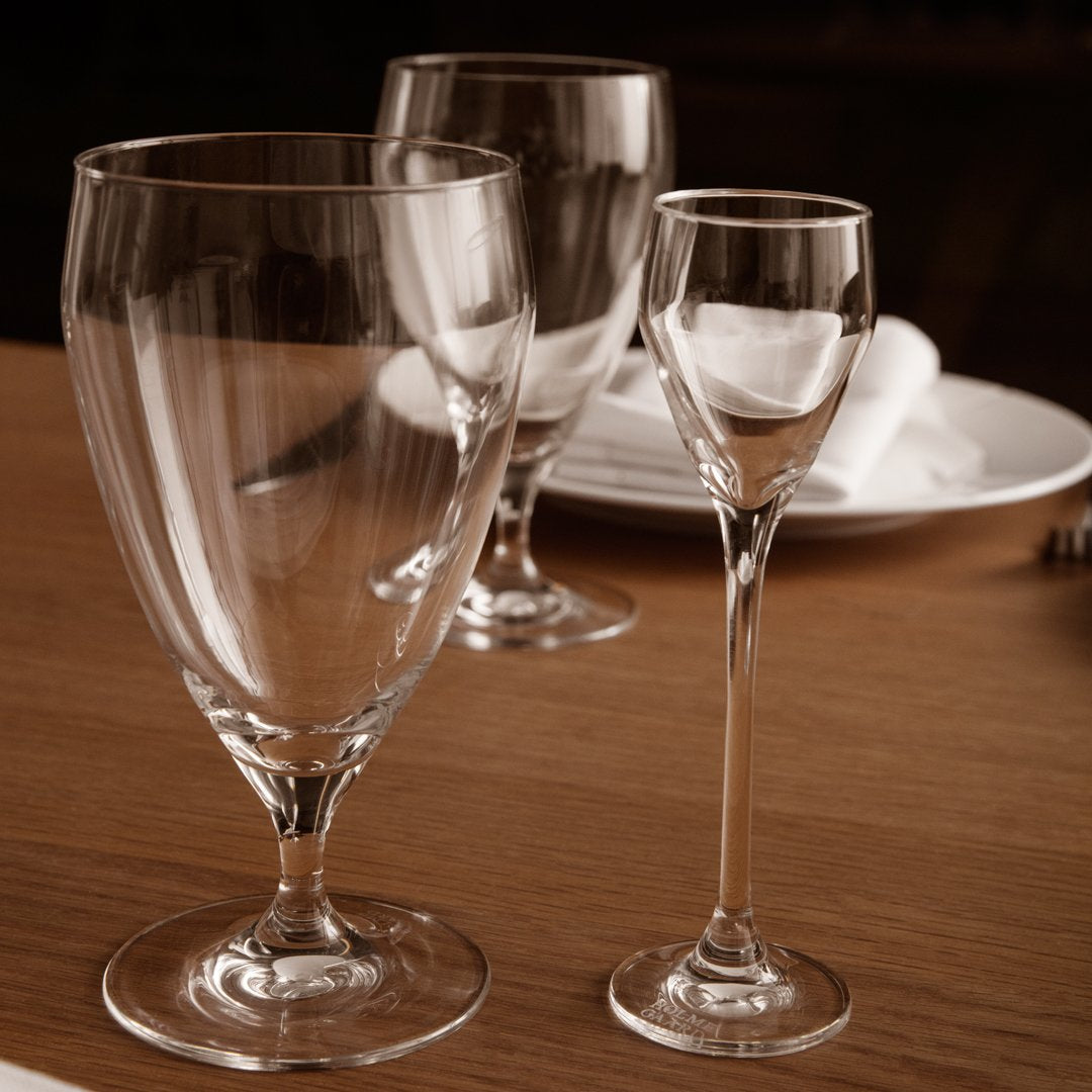 Clear glassware set featuring three elegant designs: a large goblet, medium glass, and a delicate shot glass.