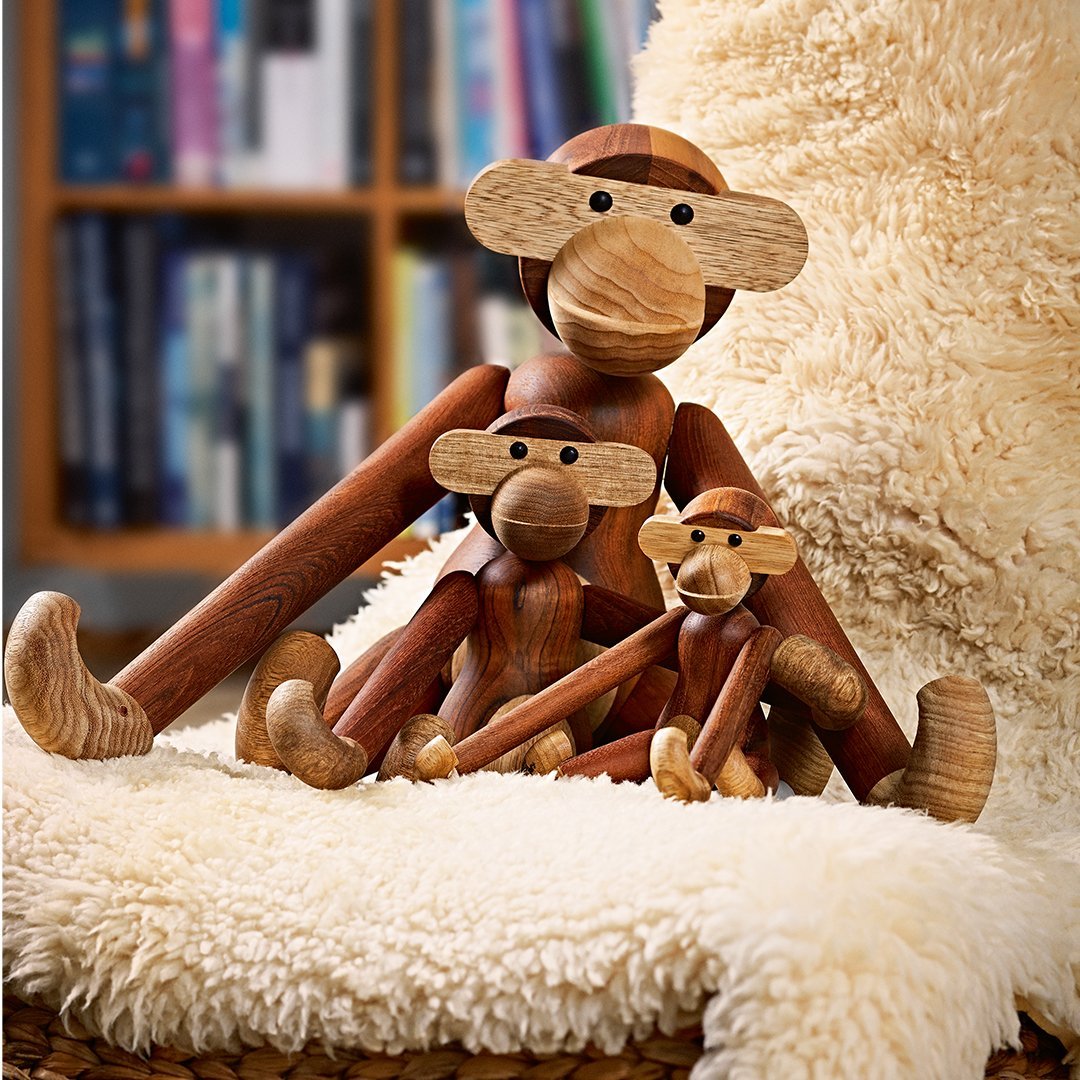 Wooden monkey figurines in warm brown tones, featuring smooth finishes and playful designs displayed on a cozy cream backdrop.