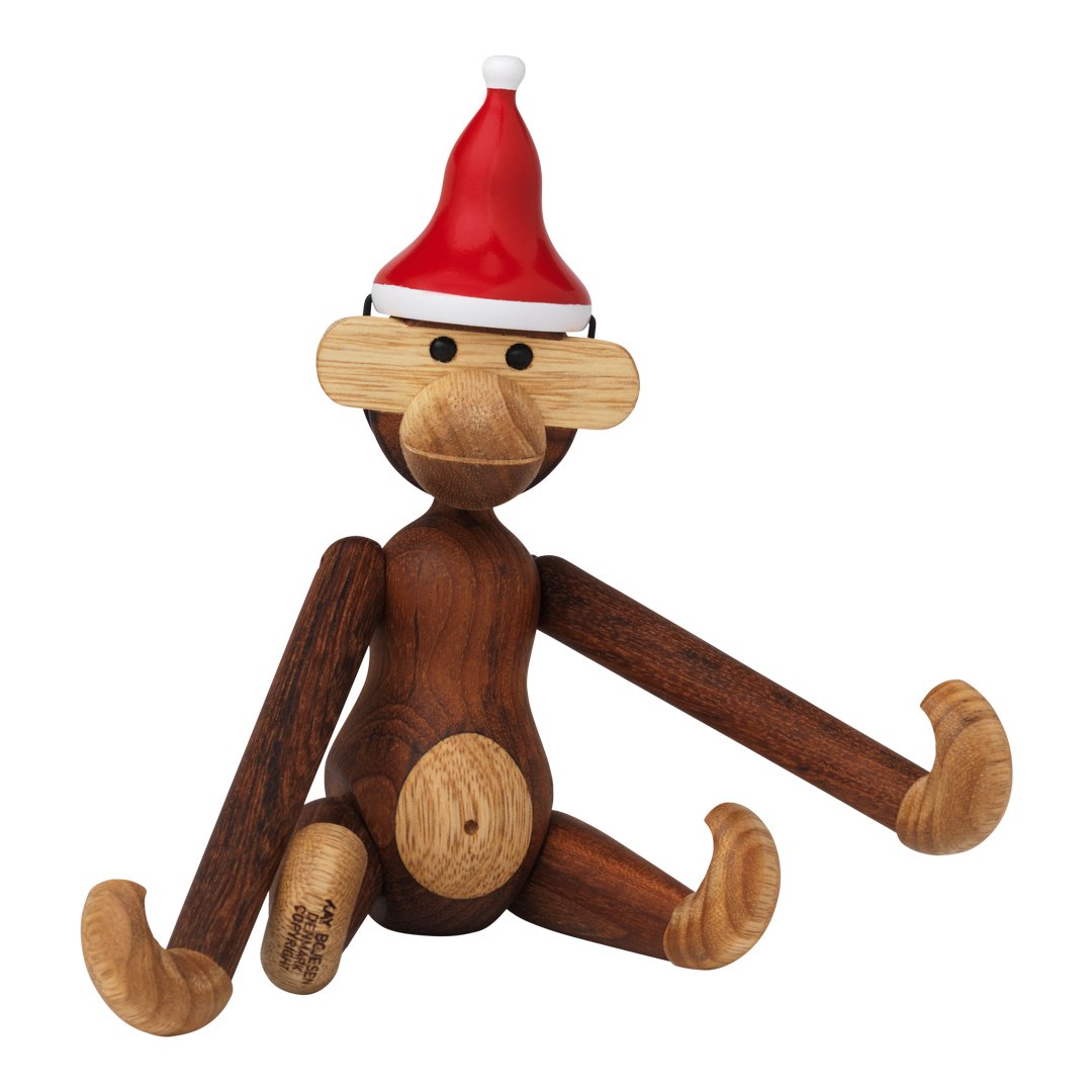 Wooden monkey figurine in brown and light wood hues, wearing a festive red Santa hat.