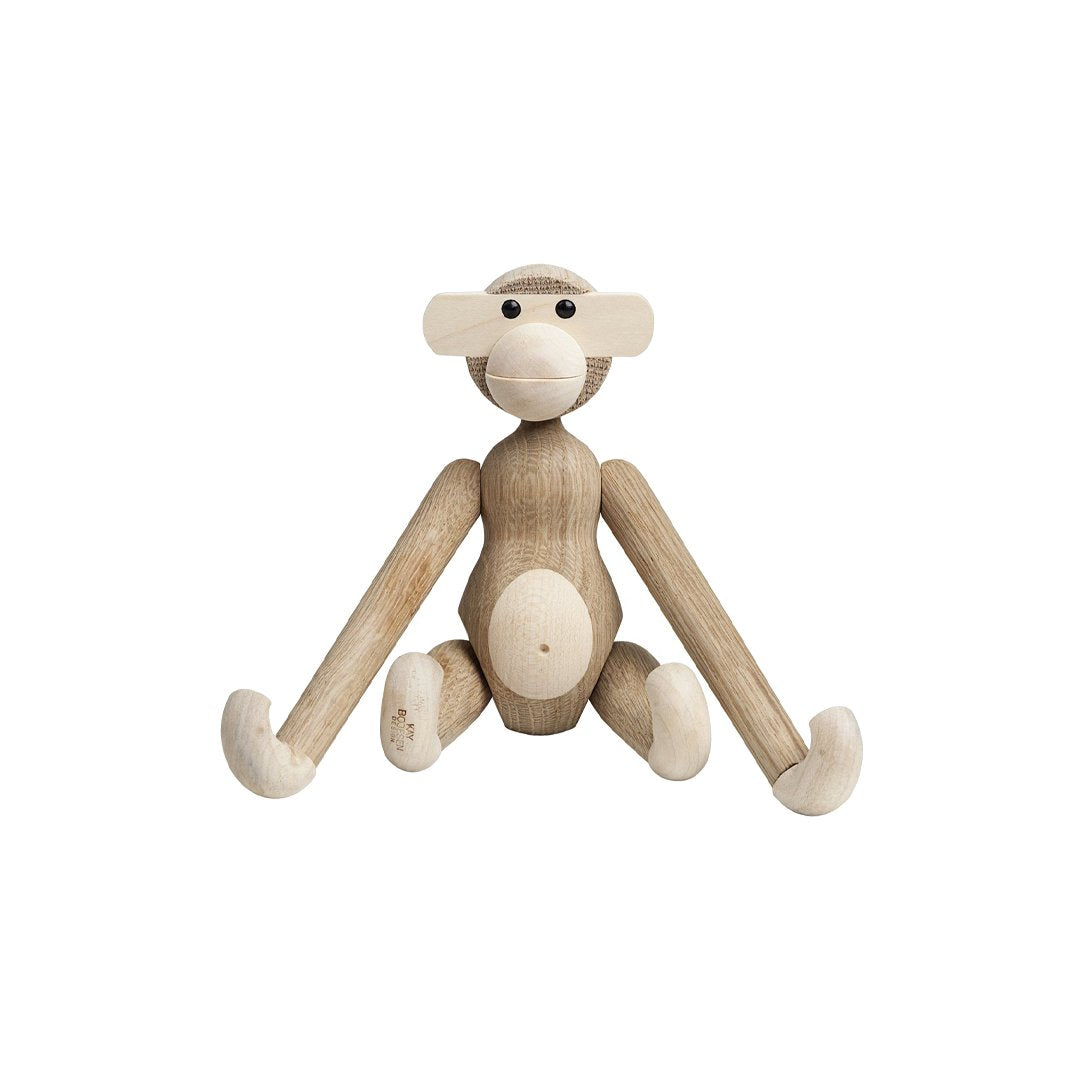 Wooden monkey figurine in natural wood tones with smooth, rounded features and minimalist design.