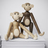 Wooden monkey figurines in natural beige and brown hues, featuring smooth finishes and minimalist designs.