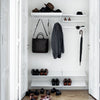 White closet with gray clothing and black accessories, featuring a sleek, minimalist design with organized shoes below.