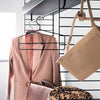 Pink blazer, neutral tan bag, and leopard print purse hang on a sleek black rack, vibrant and stylish.