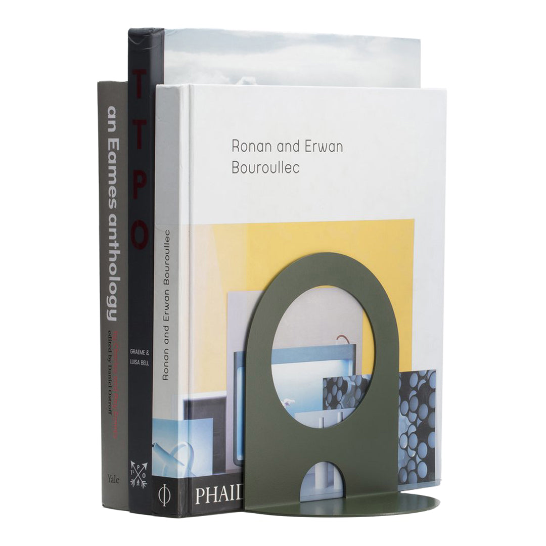 Green bookend with a circular cutout, featuring bold colors and modern geometric patterns on surrounding books.