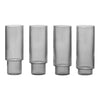 Set of four tall, textured glass vases in a sleek smoky gray color with vertical ribbed patterns. 