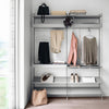 "Minimalist gray shelving with neutral-toned clothing and accessories, featuring soft pastel patterns."