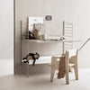 Minimalist beige desk with metal accents, featuring a smooth surface and simple lines against a soft, neutral background.