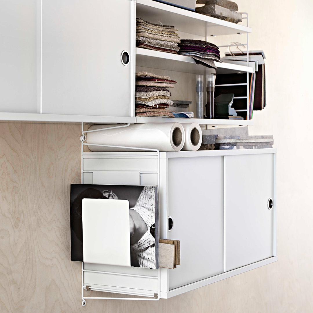 White modular shelving unit with a clean design, showcasing various stacked textiles and a smooth surface.