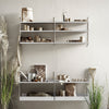 "Minimalist white shelving with natural wood and earthy tones, showcasing a blend of textures and organic decor."