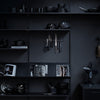 Black kitchenware and utensils on dark shelves, creating a sleek and modern monochrome aesthetic.