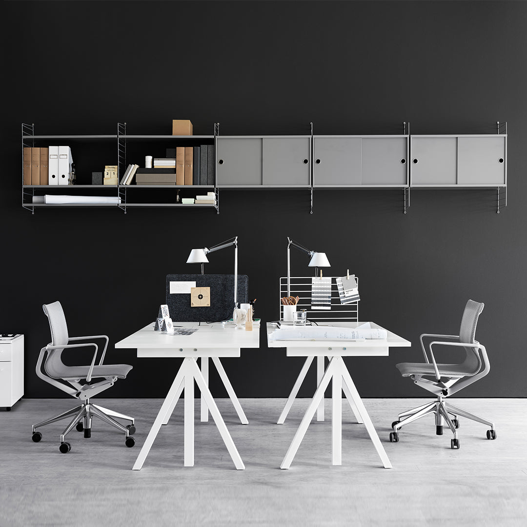 Modern office setup with white desks, gray shelving, white chairs, and a dark wall background for a sleek look.