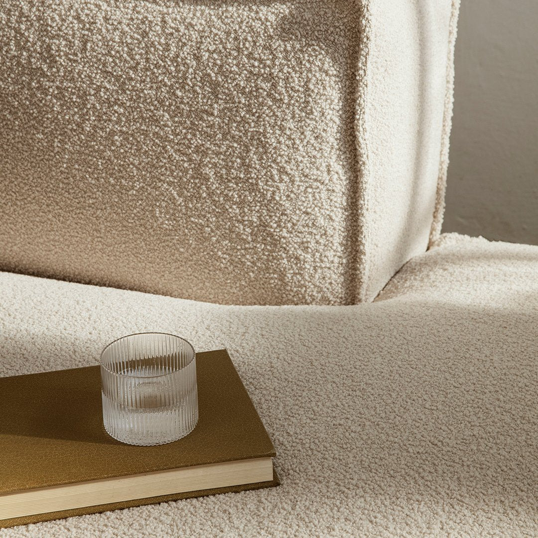 Soft beige texture with a cozy, plush pattern, complemented by a minimalist glass and book for a warm aesthetic.