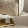 Soft beige texture with a cozy, plush pattern, complemented by a minimalist glass and book for a warm aesthetic.