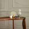 Wooden table with neutral tones, cream and amber accents, featuring geometric patterns and elegant shapes.