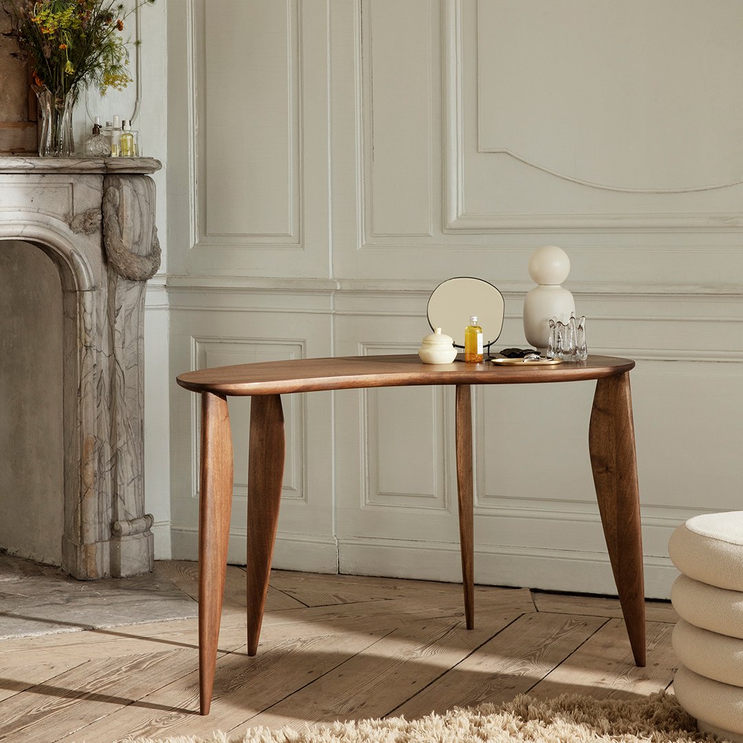 Elegant walnut table with smooth curves, showcasing rich brown tones and a minimalist design against a neutral backdrop.
