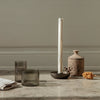 "Neutral tones with textured glass and a rustic clay vase, featuring soft earth colors and subtle patterns."