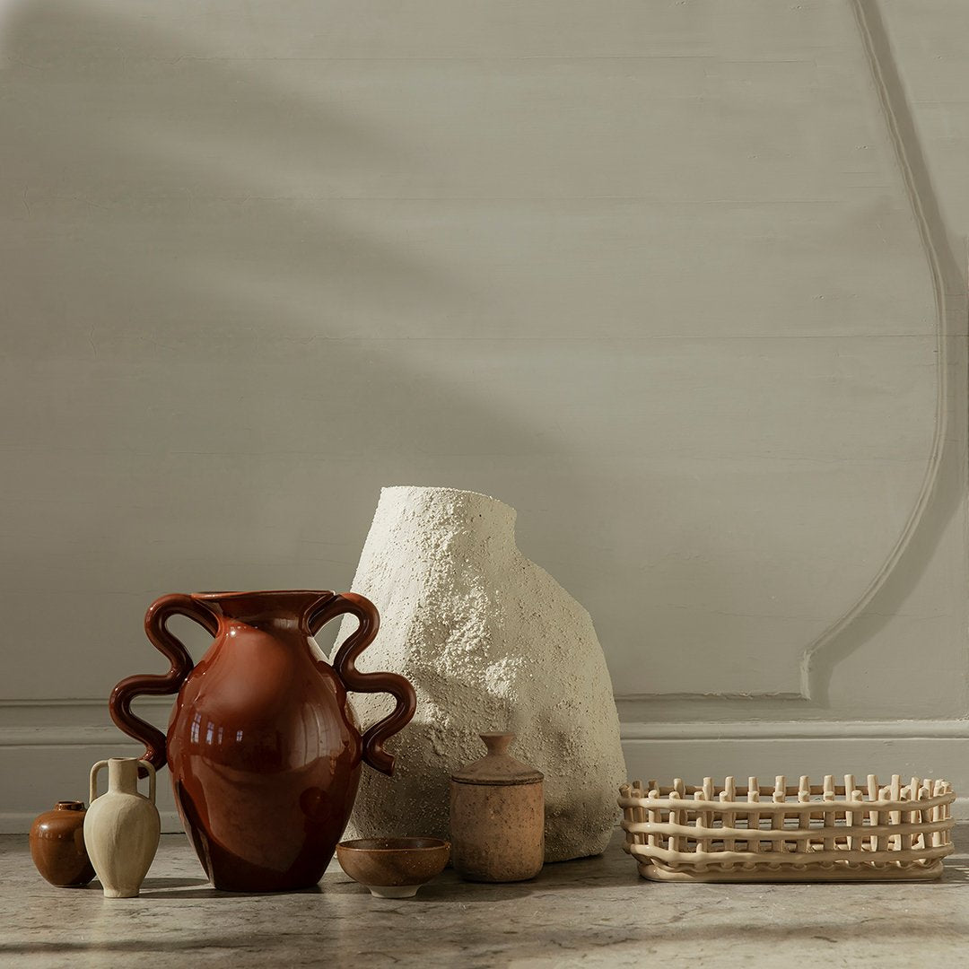 "Collection of earthy-toned vases and textured pottery against a soft, neutral background."