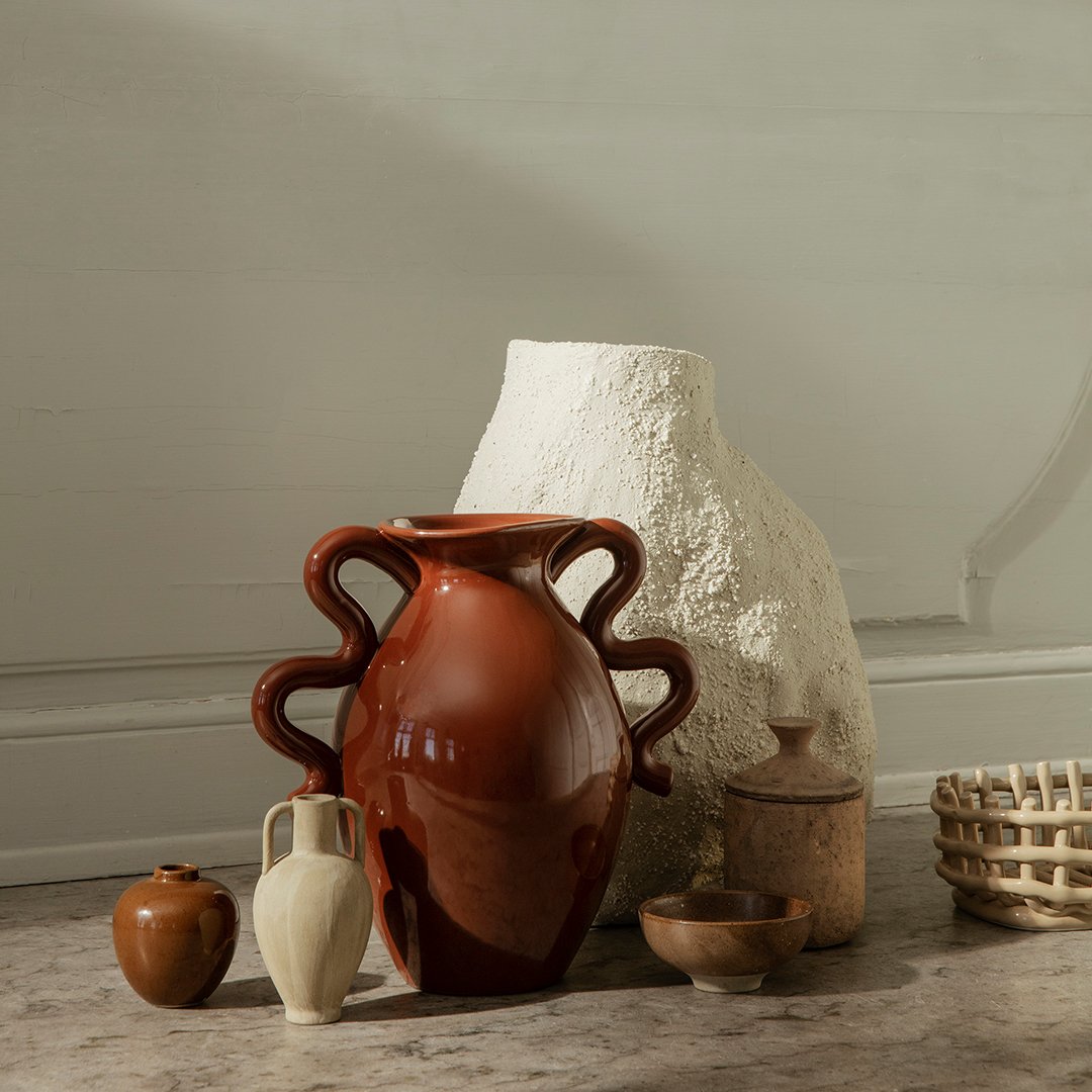 "Set of earthy-toned vases in terracotta, white, and light beige with varied textures and organic shapes."