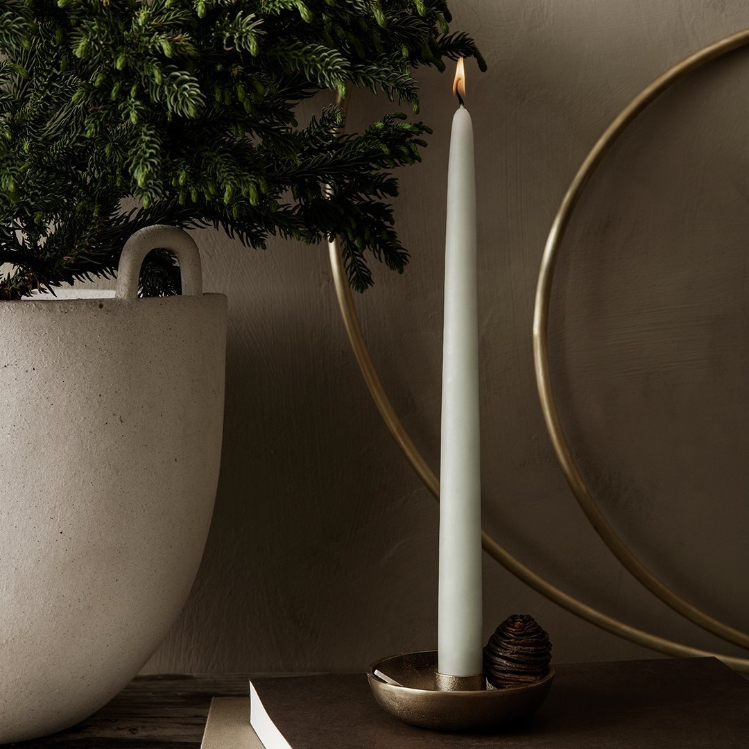 Mint green candle with a sleek design, set against a neutral backdrop, complemented by gold and earthy elements.