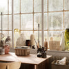 "Collection of textured vases in soft neutrals, greens, and browns, arranged by a sunlit window."