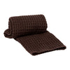 Brown textured blanket featuring a cozy waffle pattern, perfect for adding warmth and style to any space.
