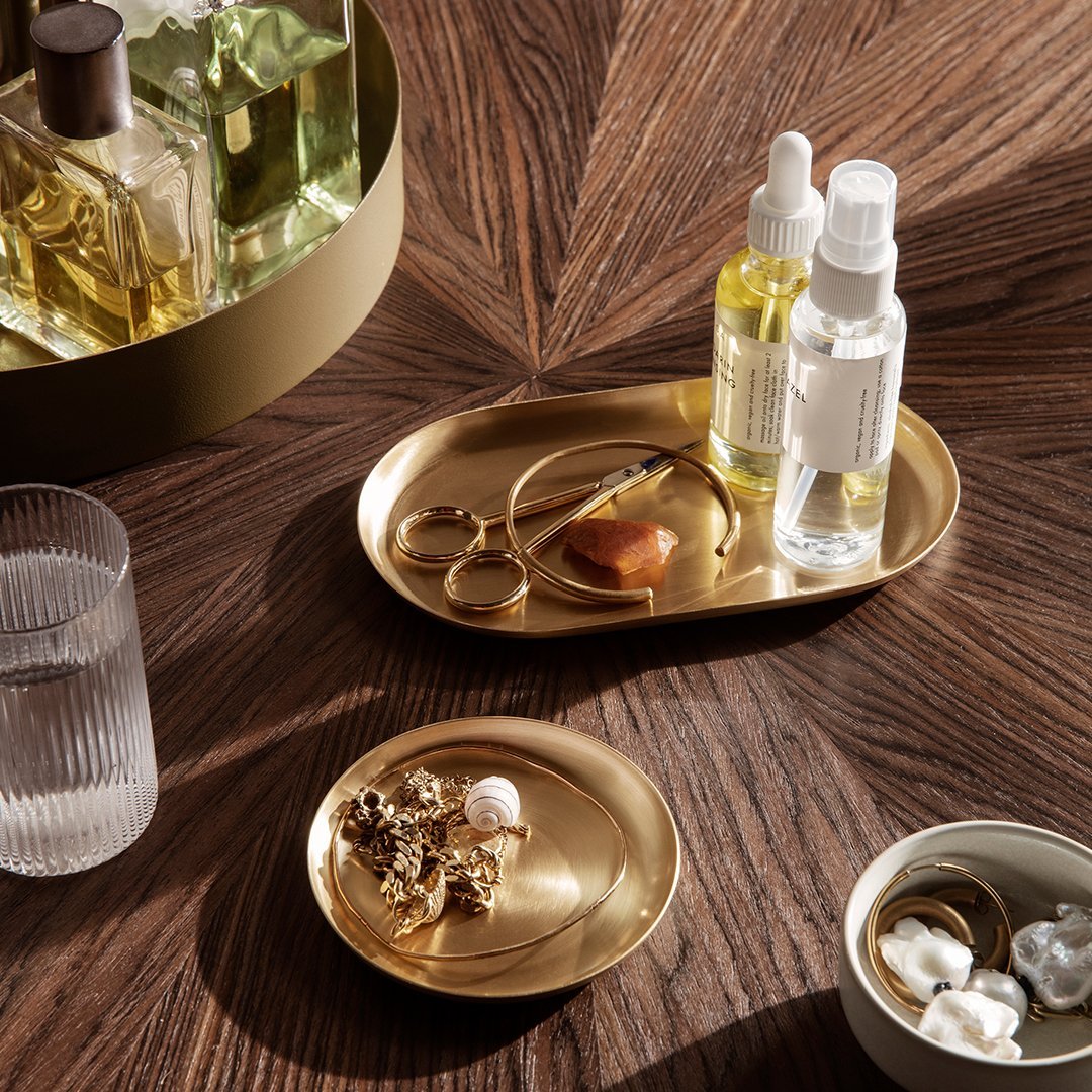 Gold and white trays on a rich wooden surface, showcasing elegant patterns and luxurious textures.