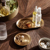 Gold and white trays on a rich wooden surface, showcasing elegant patterns and luxurious textures.