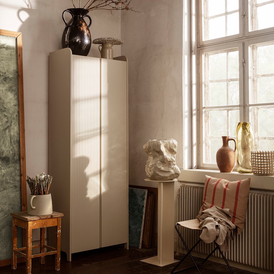Minimalist beige cabinet against a soft, muted wall, complemented by earthy tones and natural textures.