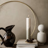 Modern decor with a sleek white candle, black ceramic jug, and white accent statue against a neutral backdrop.