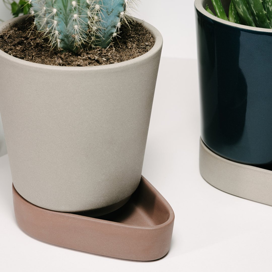 Neutral beige pot with brown base, paired with a deep navy pot, showcasing a modern minimalist design and earthy tones.